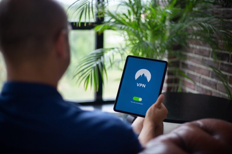 Mann hält Tablet in seiner linken Hand. Auf dem Tablet ist eine VPN-App geöffnet. Die VPN-Verbindung ist derweil aktiviert.